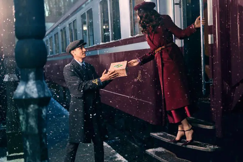 uomo che dà un regalo a una donna su un treno